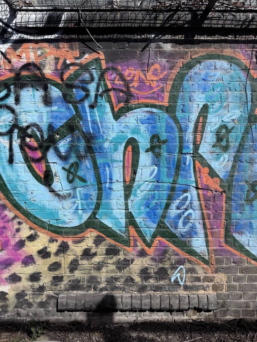 Aerosol graffiti covering London stock brick wall before removal
